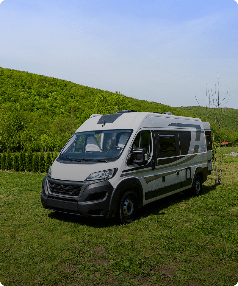 Recreational vehicle near green hills